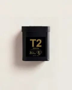 Black T2 Matcha powdered green tea tin with gold label on an off-white background