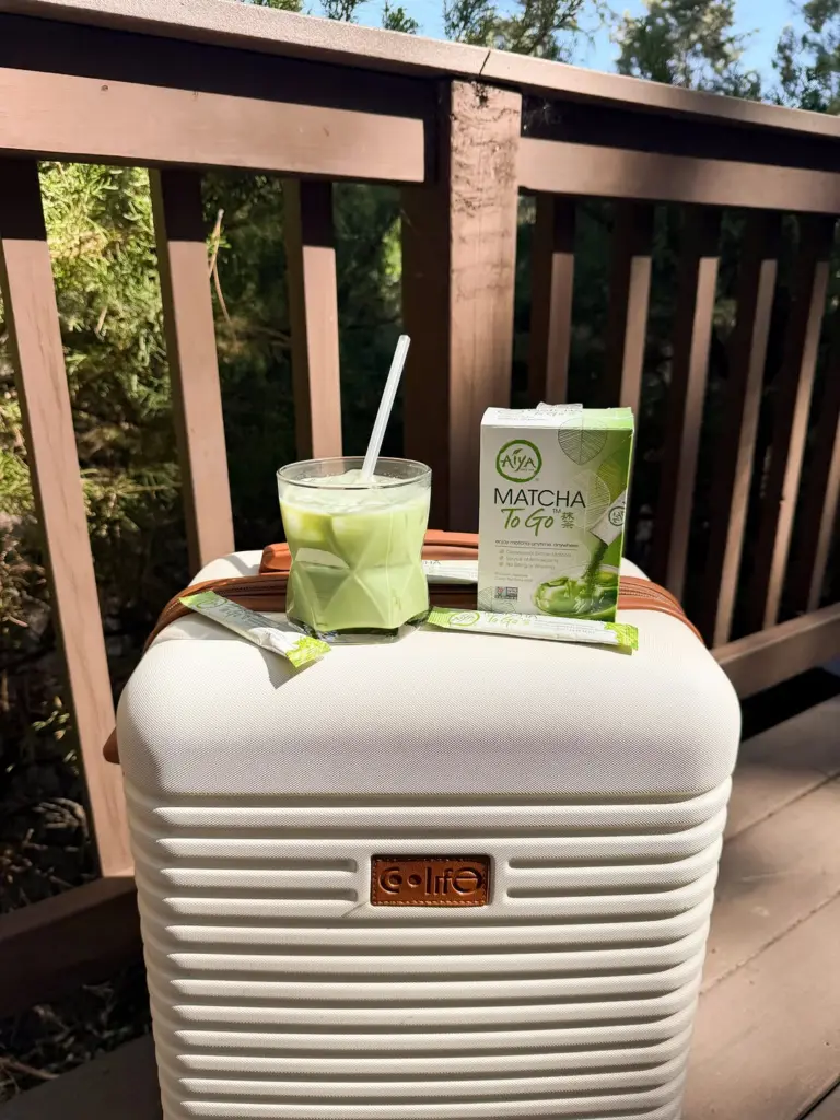 Iced matcha, Matcha To Go box, and packets arranged on a white suitcase