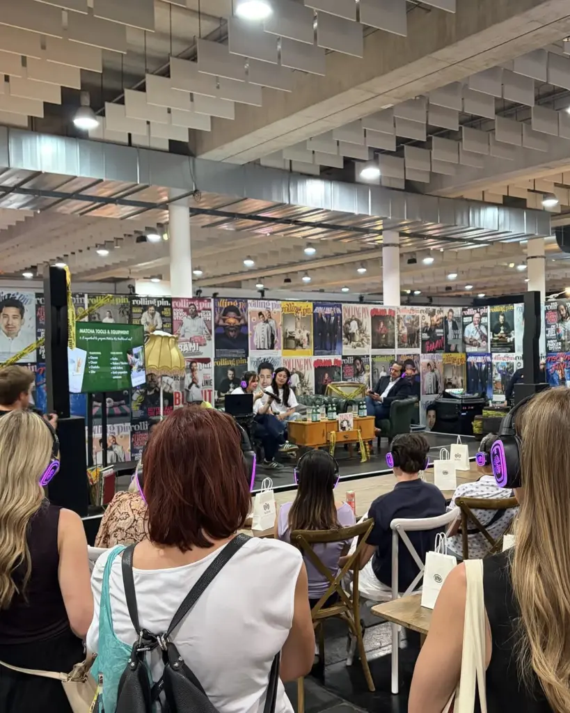 Seated audience wearing headphones during a matcha tools presentation