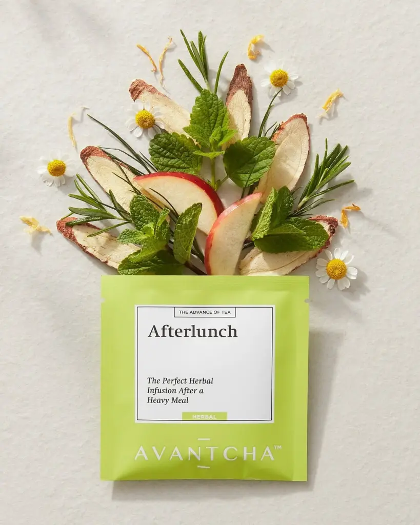 Green AVANTCHA Afterlunch packet arranged with apple slices, mint, rosemary, roots, and small white flowers