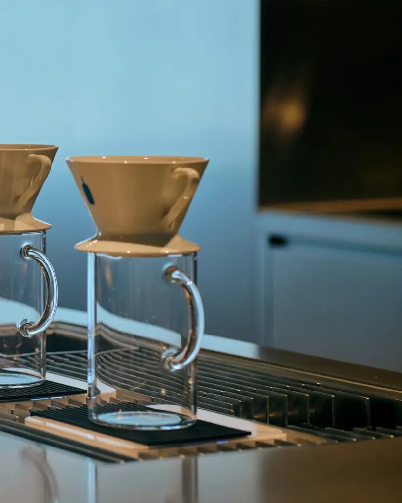 White ceramic dripper set over a clear handled glass pitcher