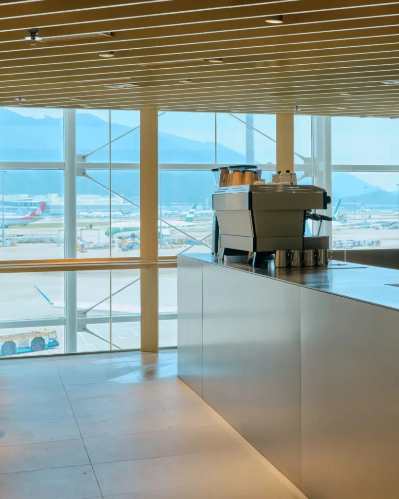 Espresso machine on a long counter overlooking parked airplanes and mountains