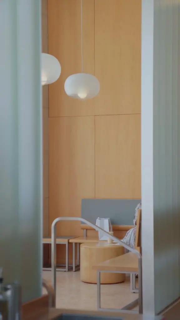 Wood-paneled seating area with round pendant lights and pale wood furniture
