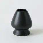 Black porcelain chasen stand with a rounded body and flared base
