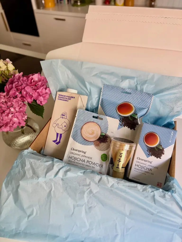 Clearspring hojicha tea and powder packages with a bamboo whisk in an open gift box