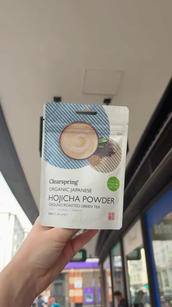 Hand holding a pouch of Clearspring Japanese Hojicha Powder