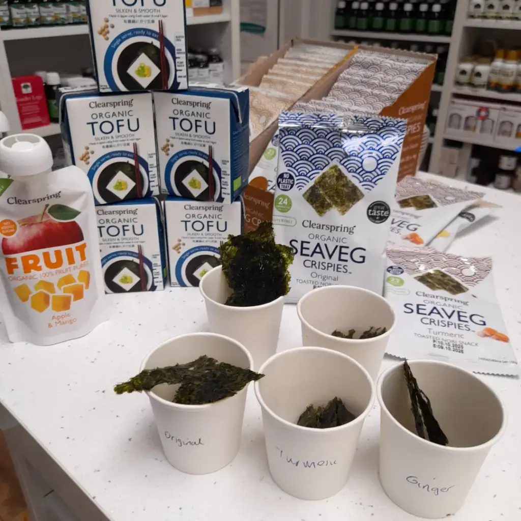 Sea vegetable crisp samples in paper cups with Clearspring packages and tofu cartons behind