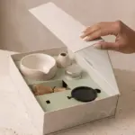 Open Tsuki Matcha gift box with a bowl, bamboo whisk, whisk holder, tin, and round black utensil