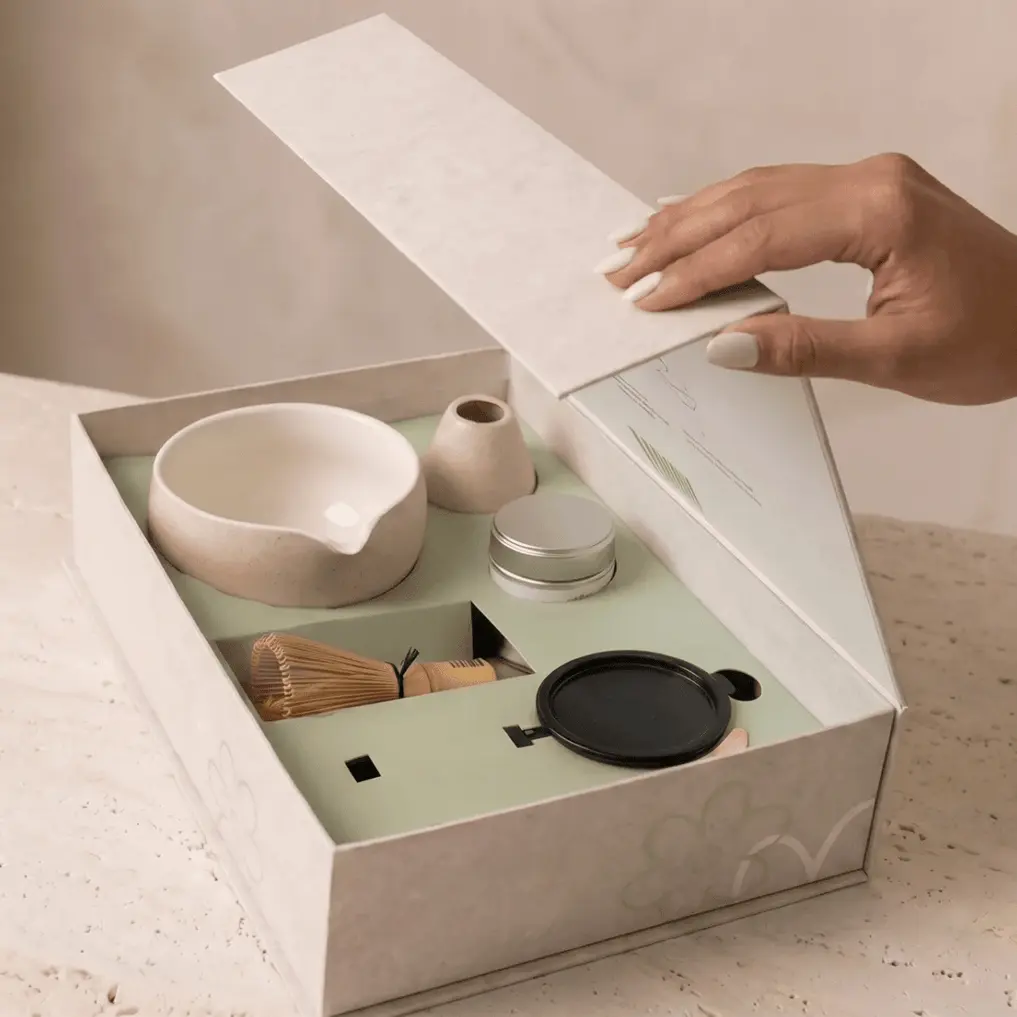 Open Tsuki Matcha gift box with a bowl, bamboo whisk, whisk holder, tin, and round black utensil