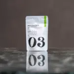 White Matcha Crew No. 03 40 g matcha pouch reflected on a dark polished surface