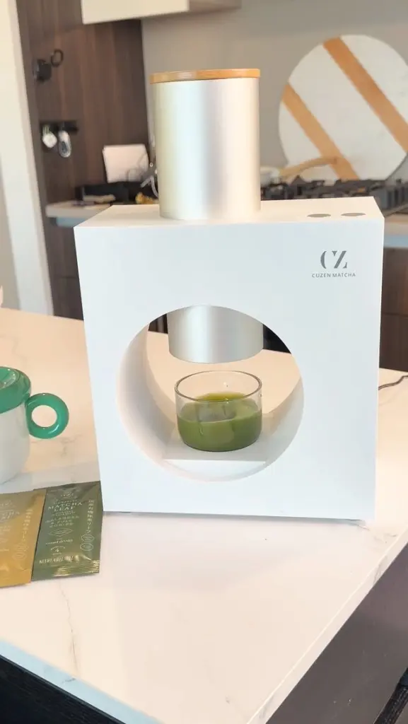 Cuzen Matcha machine dispensing into a glass of green matcha