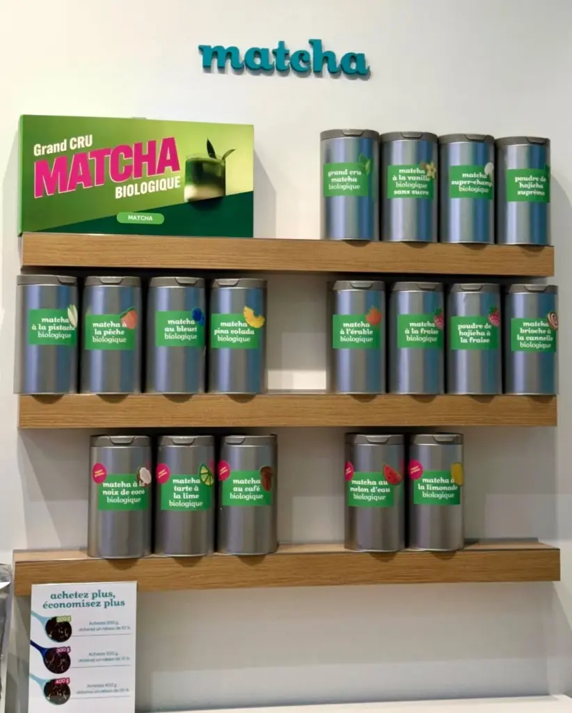 Rows of silver matcha tins on wooden store shelves