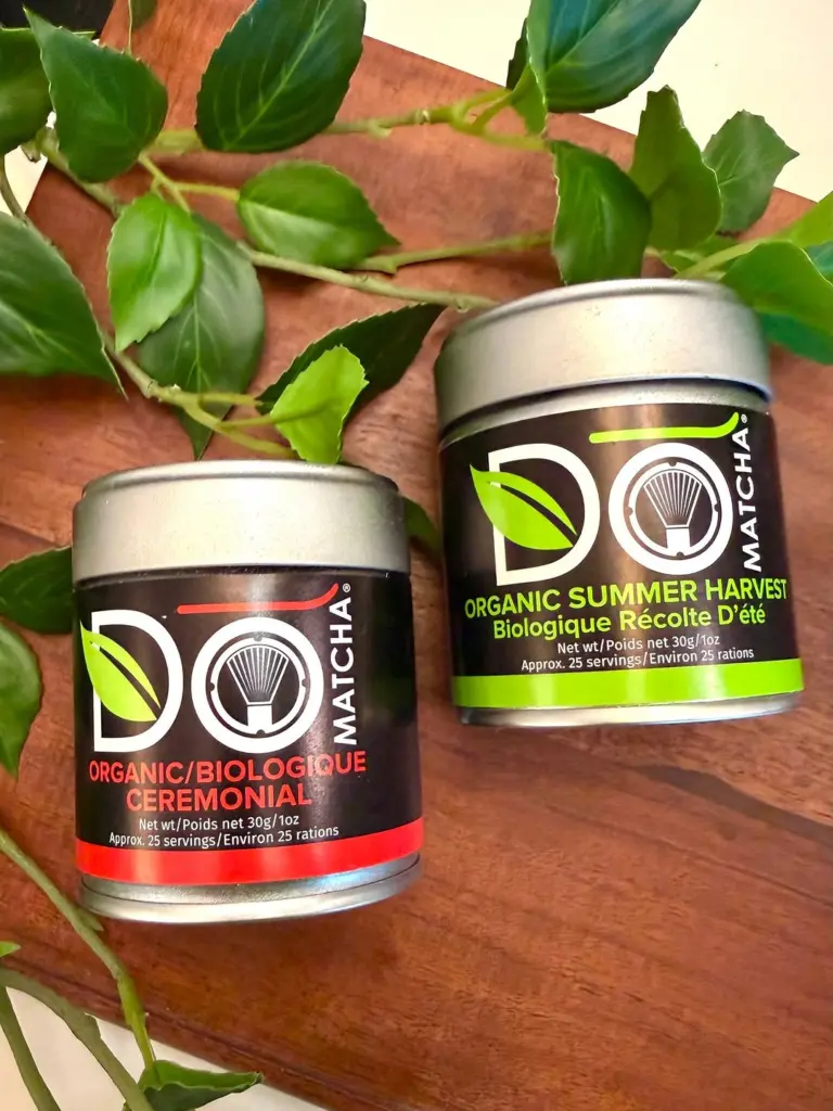 Do Matcha Ceremonial and Summer Harvest tins arranged among green leaves