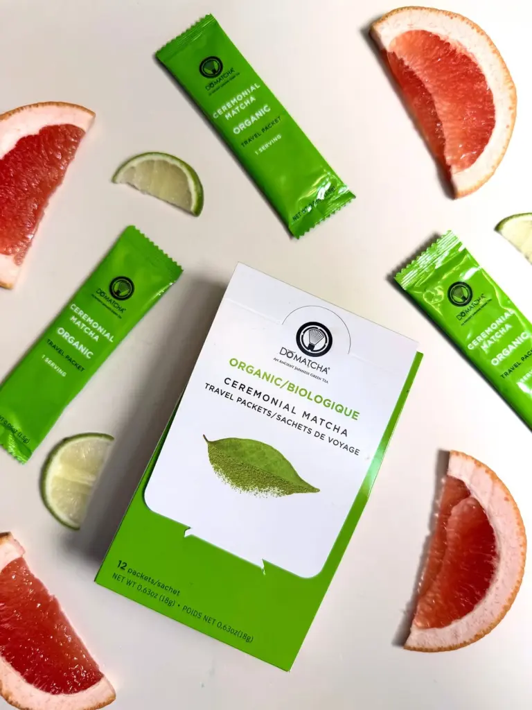 Do Matcha travel packet box and green sachets surrounded by grapefruit and lime slices