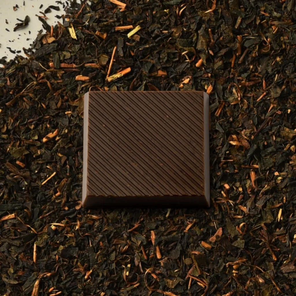 Square brown confection with diagonal ridges on dark tea leaves