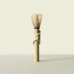 Full-length bamboo matcha whisk standing upright against a pale background