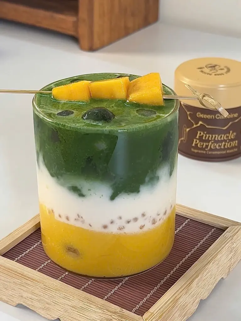 Layered iced matcha drink topped with skewered yellow fruit pieces