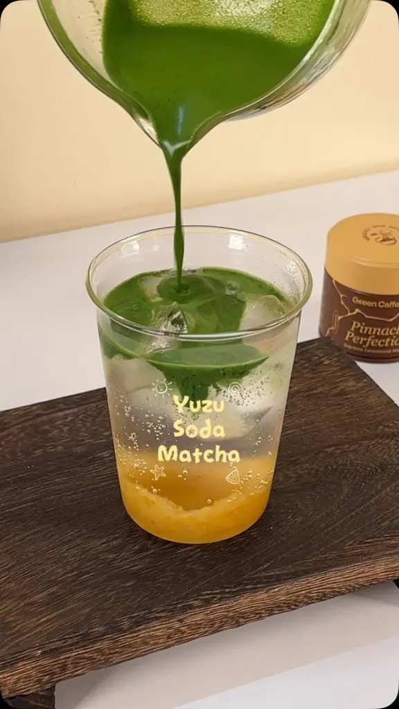 Green matcha being poured into an iced yellow soda