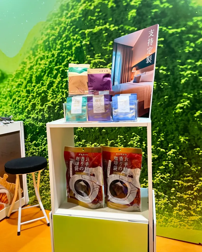 Colorful tea packets and two large red bags arranged on a white shelf