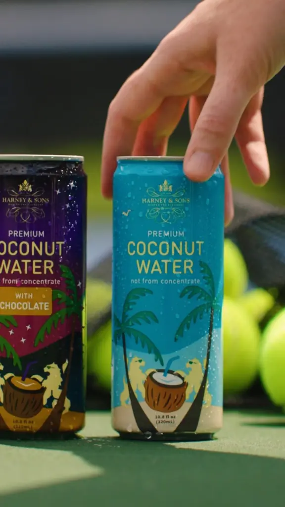 Hand reaching for a blue Harney & Sons coconut water can
