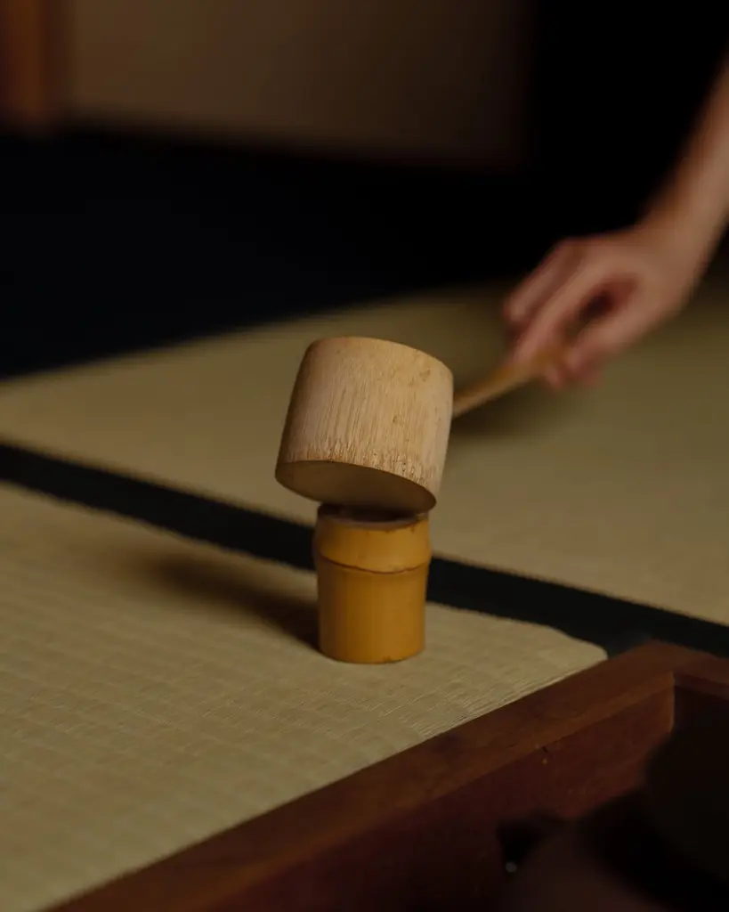 Bamboo ladle resting at an angle on a small stand