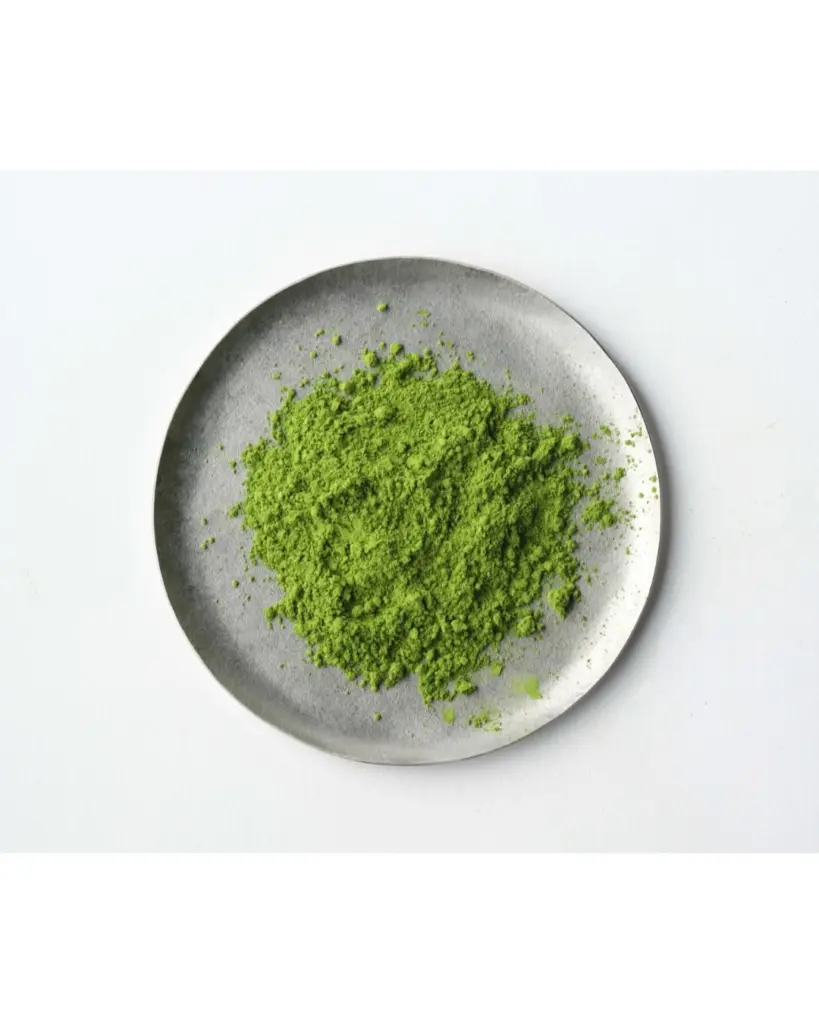 Bright green matcha powder piled on a round gray plate