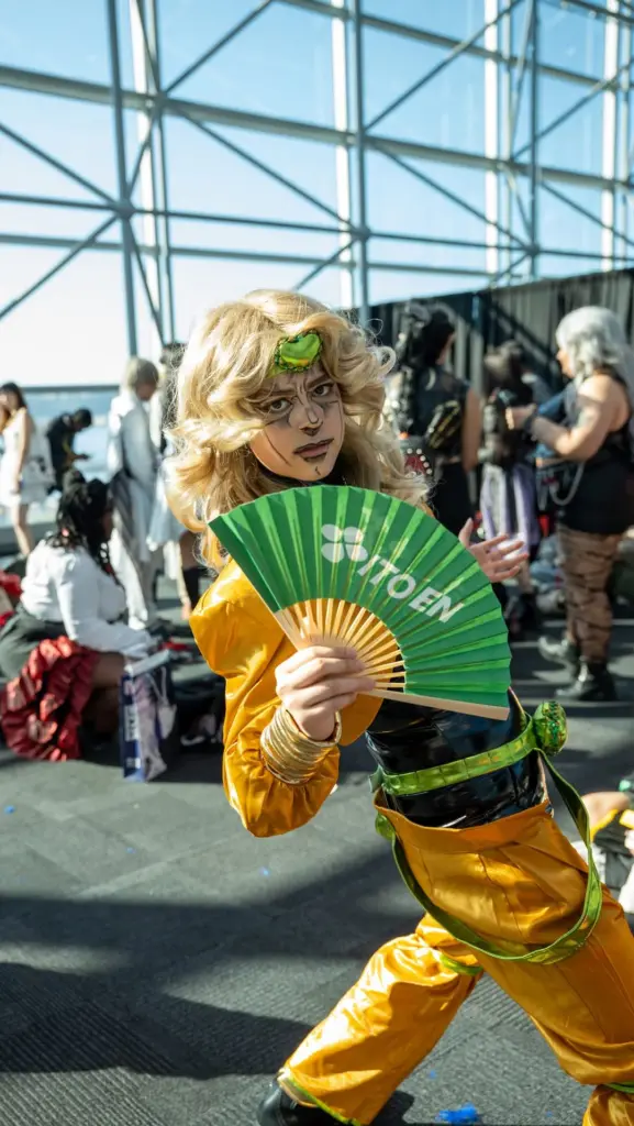 Costumed person holding a green Ito En folding fan