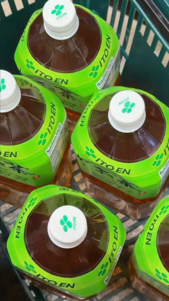 Large amber tea jugs with bright green Ito En labels in a shopping cart
