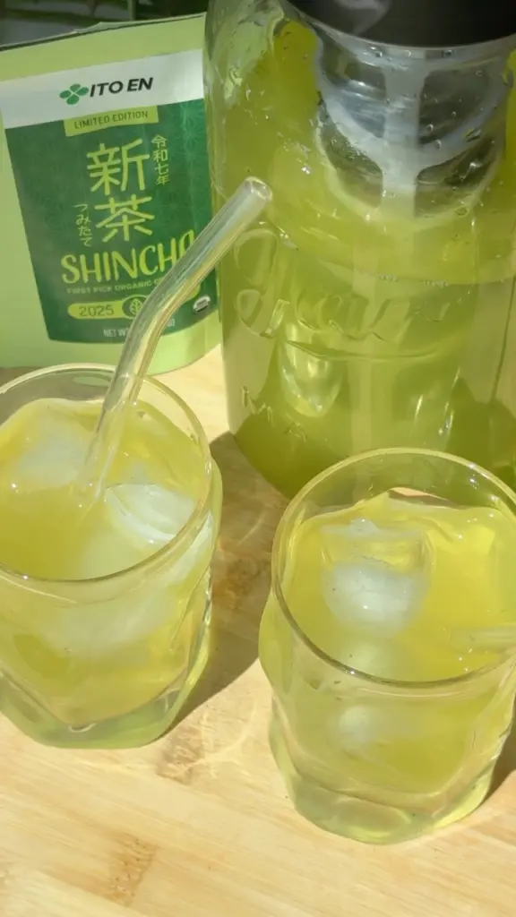 Two glasses and a pitcher of iced green tea beside an Ito En Shincha package