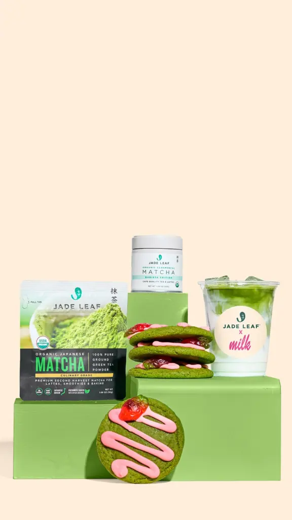 Matcha packages, an iced green latte, and green cookies with pink frosting