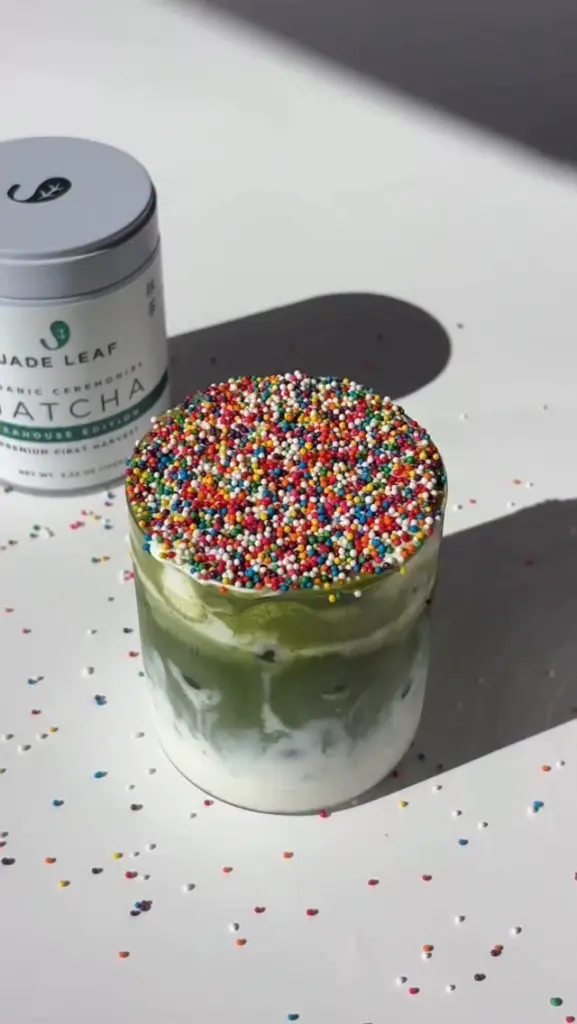 Iced matcha milk drink topped with rainbow sprinkles