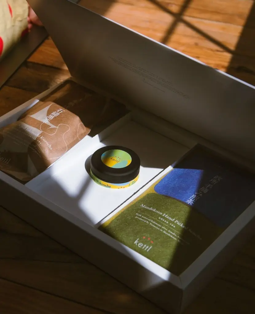Open gift box with two tea packages and a small Kettl tin