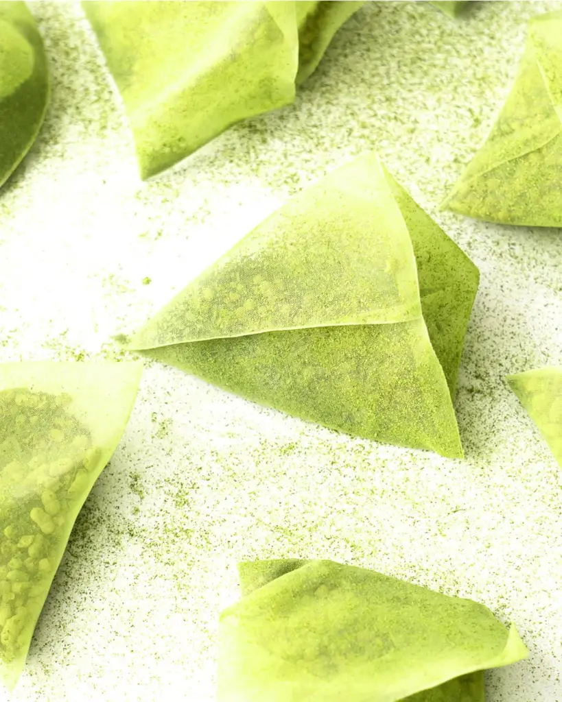 Pyramid-shaped tea bags filled with green tea