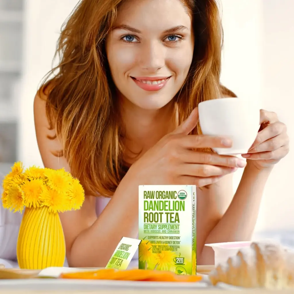 Smiling red-haired woman holding a white cup behind a box of dandelion root tea