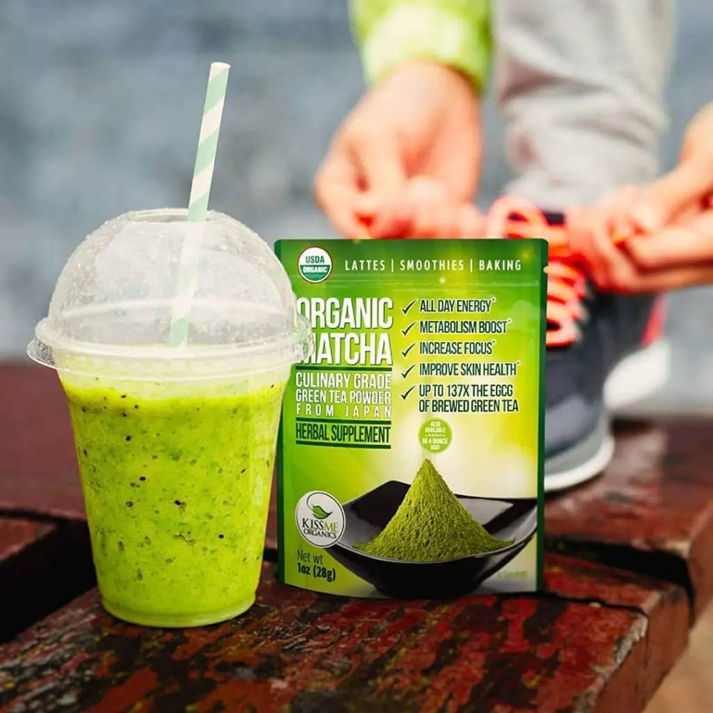 Bright green smoothie in a clear cup beside a Kiss Me Organics matcha pouch