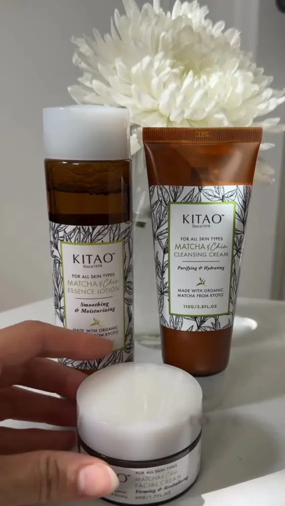 Three Kitao Matcha & Chia skincare containers with a white flower