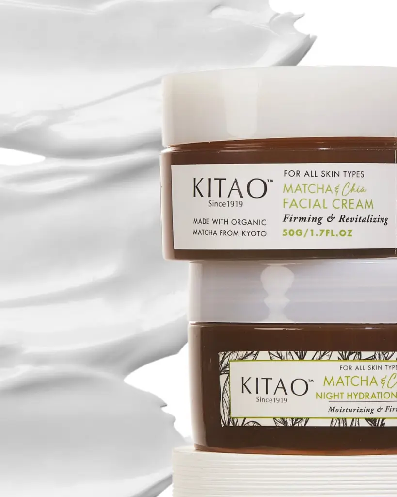 Stacked brown jars of Kitao facial cream and night hydration cream against a white textured backdrop