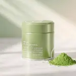 Green Le Miyazaki ceremonial matcha tin beside a mound of green matcha powder