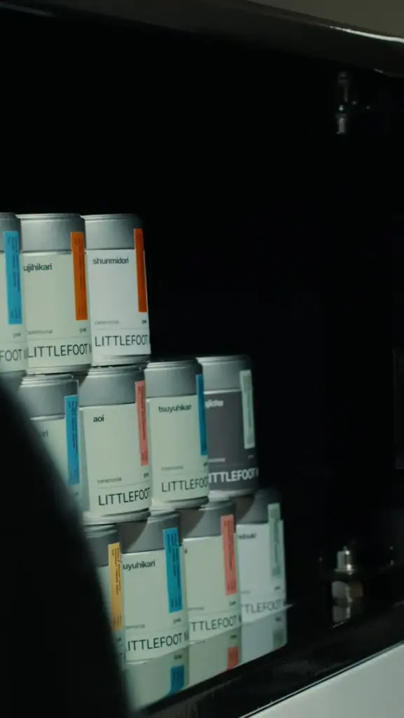 Littlefoot Matcha tins stacked inside a dark cabinet
