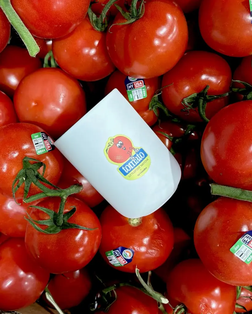 White Littlefoot Matcha cup resting on a pile of red tomatoes