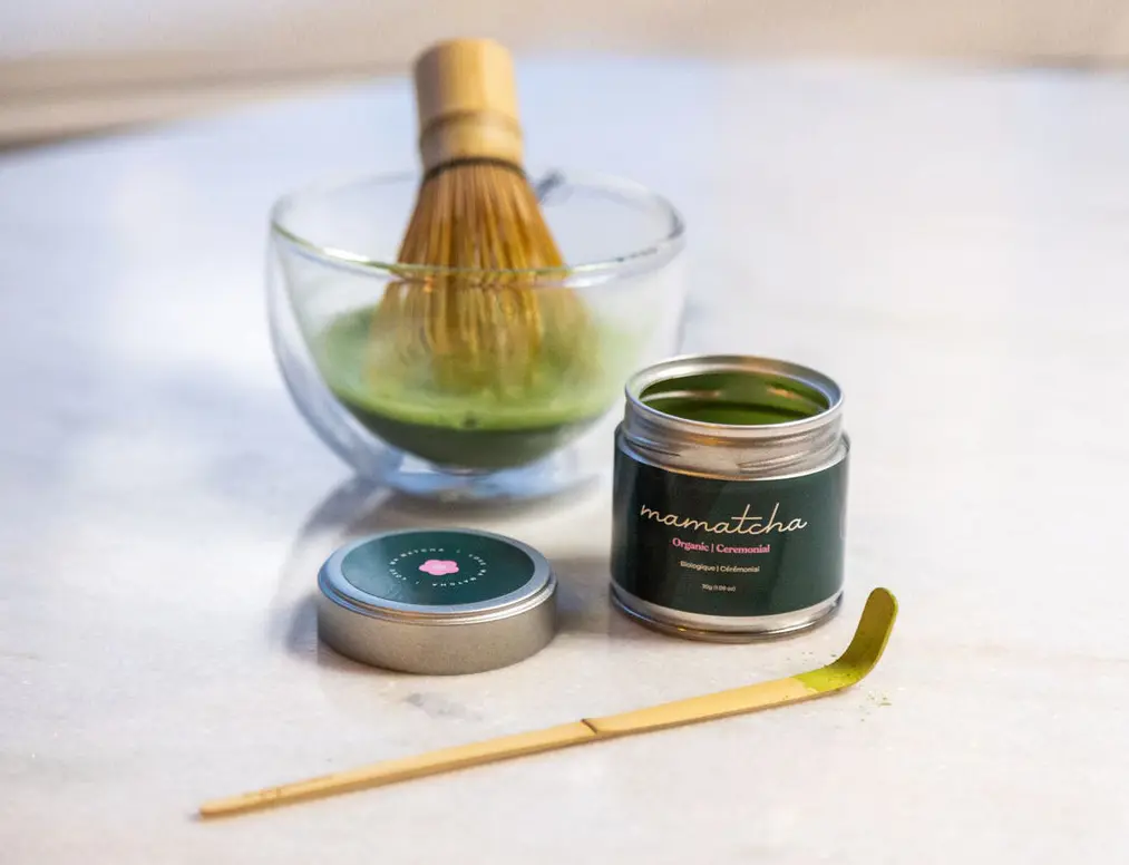 Mamatcha matcha jar, bamboo whisk, scoop, and bowl with green matcha