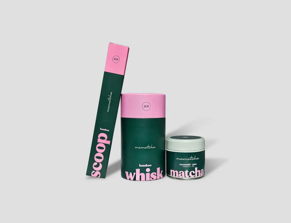 Mamatcha set with matcha tin, bamboo whisk box, and scoop box in pink and dark green packaging
