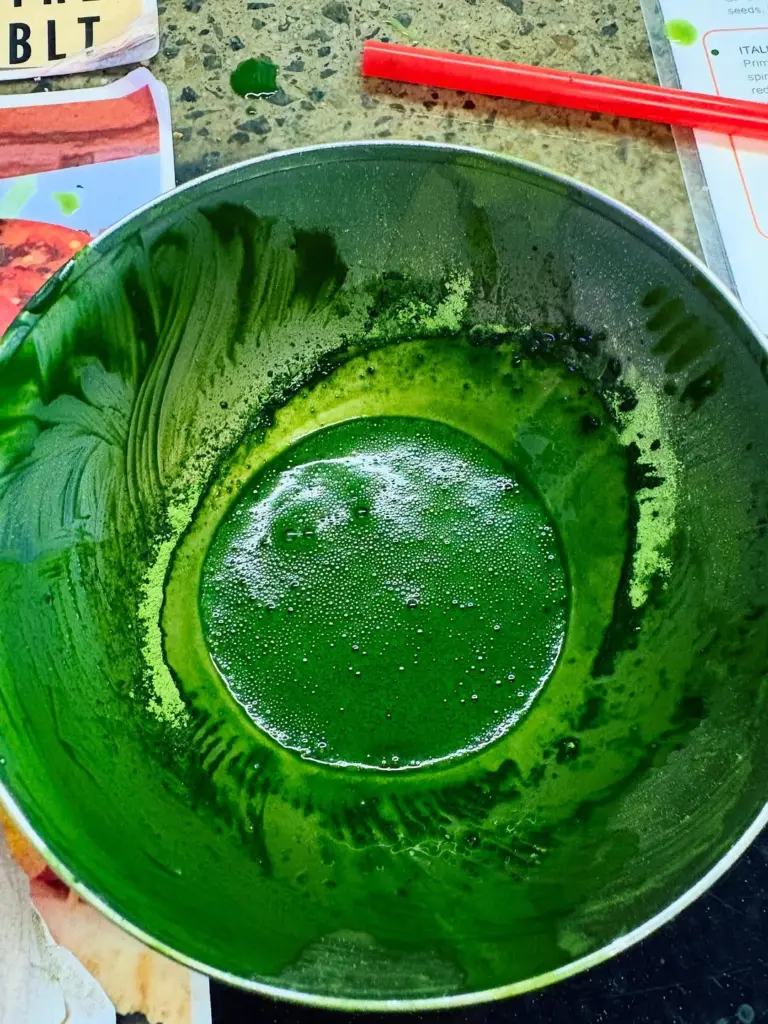 Bright green whisked tea with fine bubbles in a metal bowl