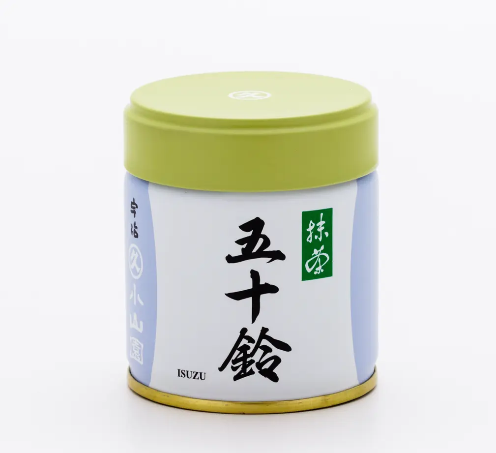 White and pale blue matcha tin with green lid, labeled 五十鈴 ISUZU with Marukyu Koyamaen mark