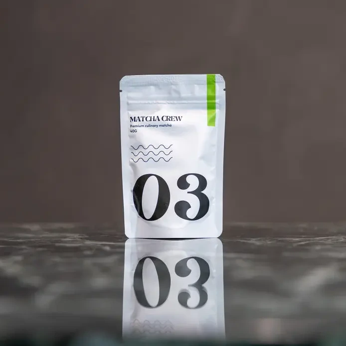 Matcha Crew No. 03 culinary matcha pouch on a dark reflective surface