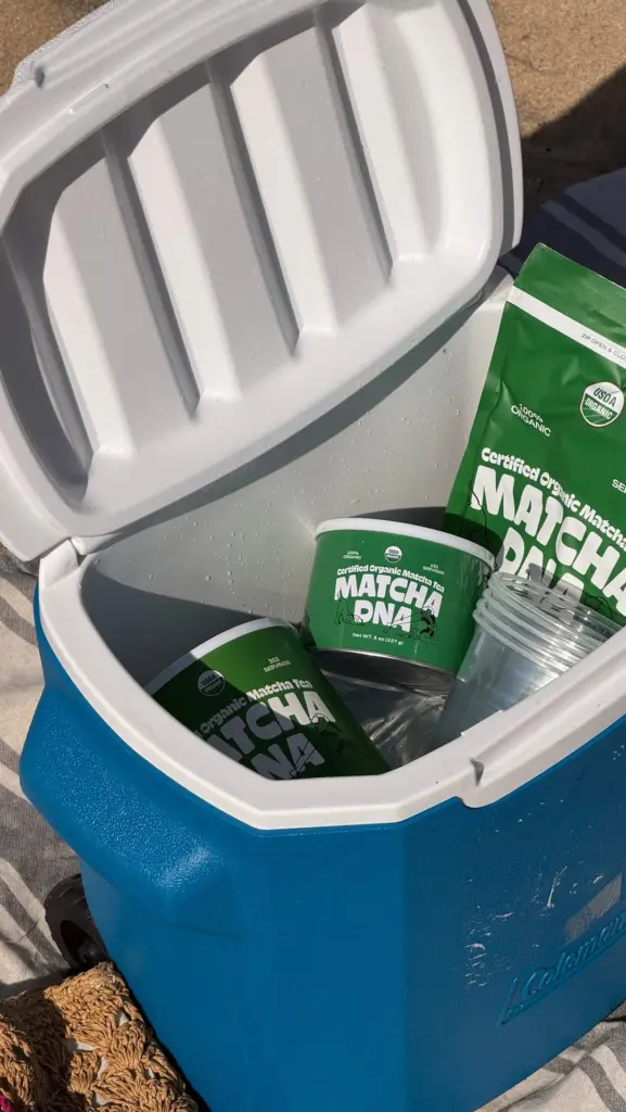 Green Matcha DNA packages and clear cups arranged inside an open blue cooler