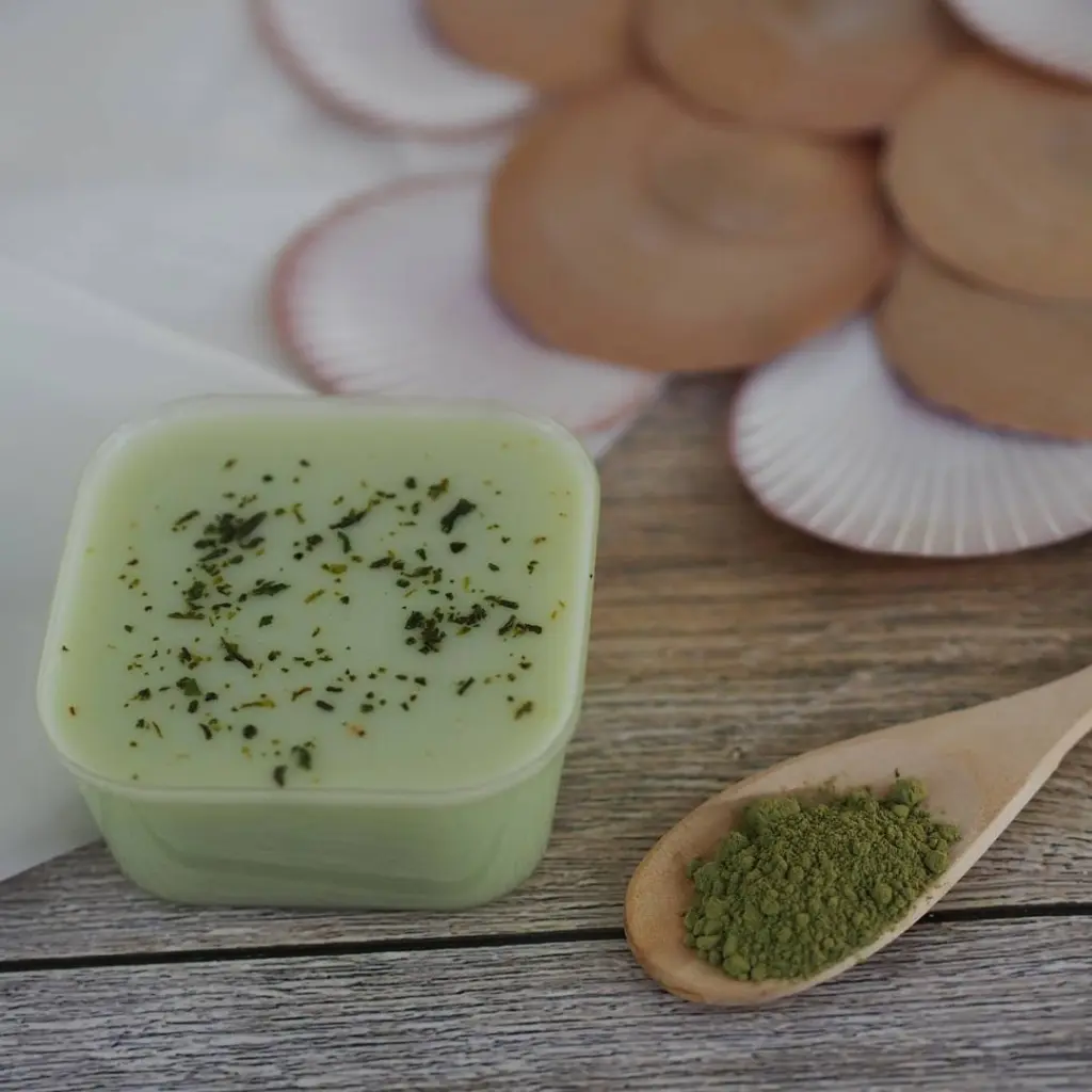 Pale green pudding beside a wooden scoop of green powder