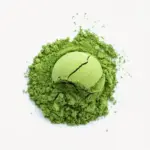 Rounded scoop of green matcha resting on a loose mound of powder