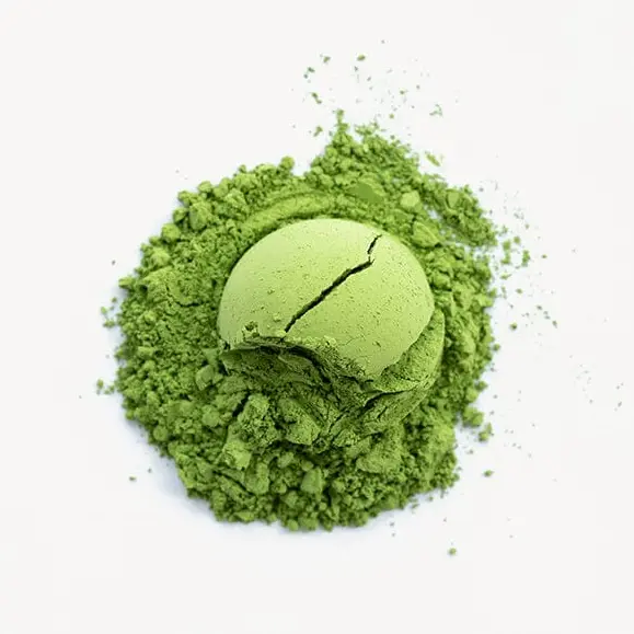 Rounded scoop of green matcha resting on a loose mound of powder