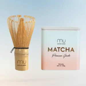 Bamboo matcha whisk beside a Matcha Union Premium Grade matcha tin
